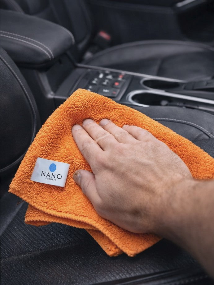 Mana care curata interiorul masinii cu laveta portocalie din microfibra